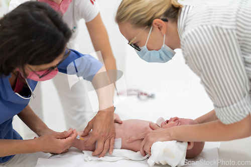 Image of Baby beeing vaccinated by pediatrician in presence of his mother. Preventive vaccination against Diphtheria, whooping cough, tetanus, hepatitis, haemophilus influenzae, pneumococcus, poliomyelitis