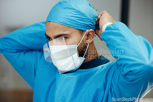 Image of Head, doctor and prepare with mask for surgery in an operating room in a medical hospital. Surgeon, clinc and healthcare professional ready to operate while apply face mask and preparing