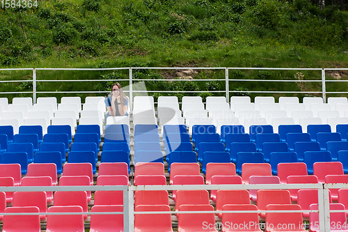 Image of Lonely woman on the empty stadium outdoor