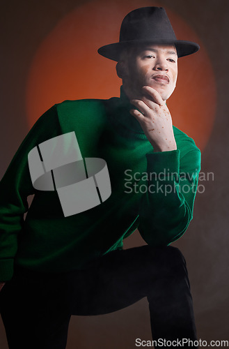 Image of Aesthetic, fashion and black man with vitiligo in studio isolated on a background. Thinking, beauty and stylish male model posing in designer hat, luxury clothing or trendy green jersey on a backdrop