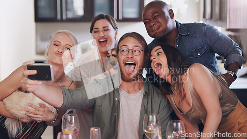Image of Friends, selfie and silly pose during dinner party at home to celebrate new years eve together. Phone, photo and funny face diverse group of people posing for a mobile picture during lunch