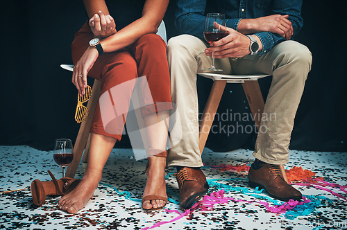 Image of Feet, man and woman sitting at a party to celebrate new years eve and socialise together. Legs, couple and celebrating while partying together at a festive celebration or event with confetti