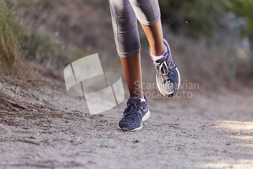 Image of Running, training and shoes of black woman on path of mountain for cardio, workout and exercise. Fitness, health and cardio with girl runner jogging on park trail for endurance, performance and goal