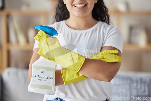 Image of Cleaning, product and spray bottle with woman in living room for hygiene, disinfection or bacteria safety. Germs, dust and chemicals with girl cleaner and arms crossed at home for housekeeper service