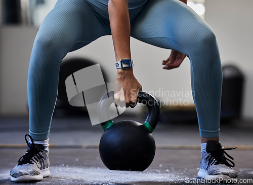 Image of Woman hand, kettlebell and gym floor in training, fitness or muscle development with smartwatch. Bodybuilder girl, weightlifting and strong with sneakers, chalk powder and focus on exercise in studio