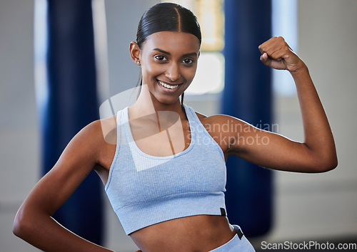 Image of Strong, fitness and muscle of woman or bodybuilder in portrait with power, motivation and energy in gym studio for training or exercise. Body goals of an Indian sports person or athlete with arm flex