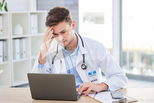 Image of Doctor, laptop and stress headache about bad news or diagnosis for medical professional in his office. Hospital, clinic and male gp specialist reading email and feeling upset with a migraine