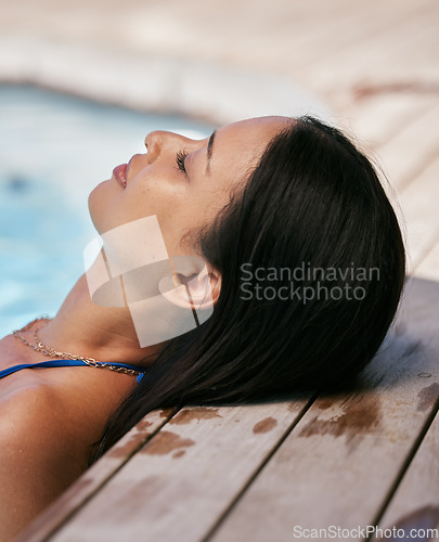 Image of Head, relax and pool with a black woman resting in the water during summer vacation or holiday alone. Luxury, swimming pool and wellness with a female tourist enjoying travel or relaxation outdoor