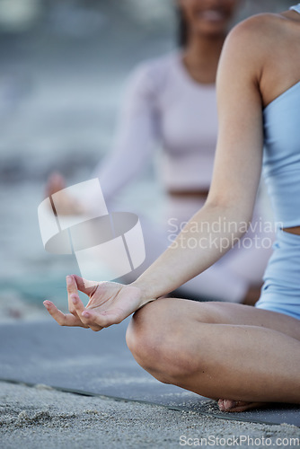 Image of Yoga, hands and friends on the beach meditating for spiritual peace and wellness mindset. Meditation, friendship and female trainers together for exercise, training and fitness with peaceful zen