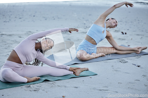 Image of Beach, stretching and yoga women or friends with fitness, exercise and nature wellness for zen, calm and peace lifestyle together. Diversity, young people and pilates training on sand by the ocean