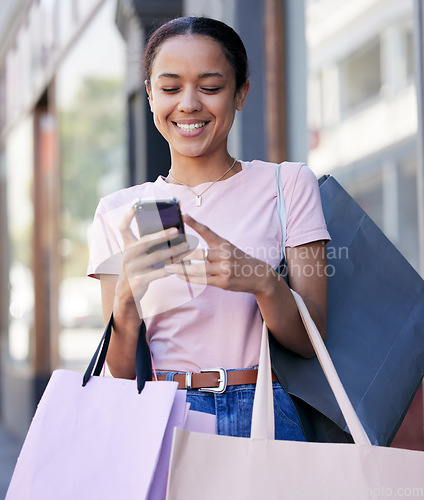 Image of Woman, phone and shopping, luxury and reading discount, sale and promotion on internet outdoor a retail store in Paris. Happy female, smile and mobile smartphone, online shopping and ecommerce