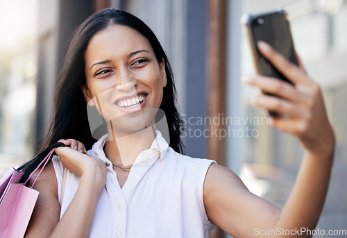 Image of Woman, phone selfie and luxury shopping, social media and picture outdoor in Miami, shopping bag and happy smile. Young female, mobile smartphone and photo outside a retail store or shopping mall