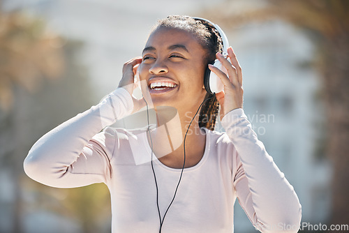 Image of Happy, fitness or black woman with headphones for a podcast, music or radio streaming for motivation in Miami. Nature, smile or healthy girl runner laughing at a funny audio after training exercise