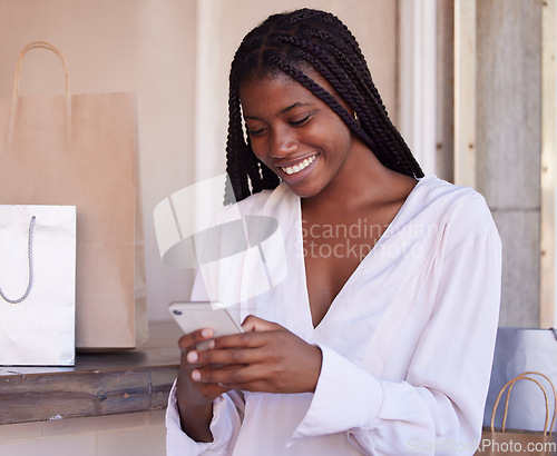 Image of Black woman, smartphone and shopping, happy and communication, retail and sale with bargain, discount with technology. Phone, shopping bag in mall and social media, text message and mobile app.