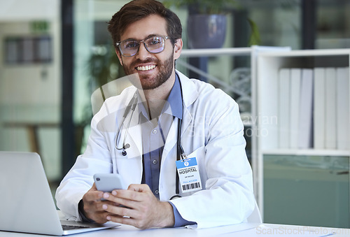 Image of Doctor, desk and phone with smile for texting, communication or chatting and good connection at hospital. Happy man healthcare or medical professional smiling for telecommunication service at clinic