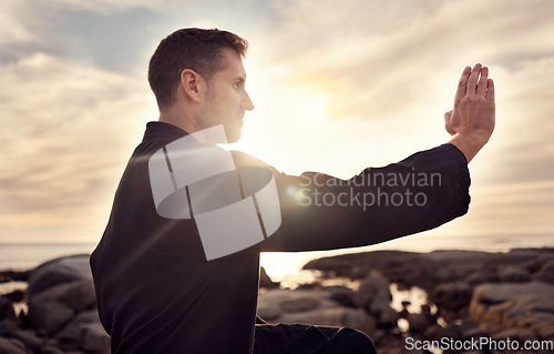 Image of Karate man, martial arts and tai chi training to fight at beach against cloudy sunset sky for focus, power and energy outdoor. Male fighter ready for sports, fighting and exercise for fitness at sea