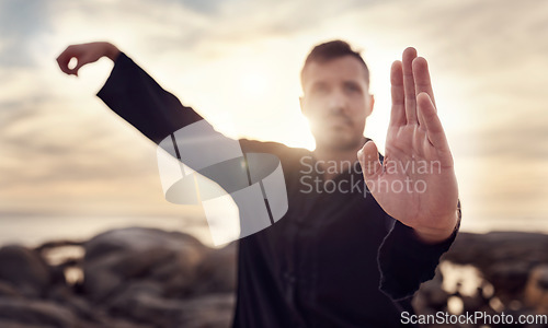 Image of Fitness, karate or man in nature training his body in a relaxing zen meditation with focus or calm sea energy. Chakra, hands or healthy martial arts expert exercising mindfulness or tai chi balance