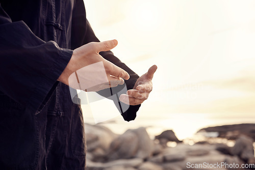 Image of Hands of Tai Chi man or meditation by beach, sea or ocean for mindset wellness, zen or fitness sport health. Zoom, martial arts or man in sunset for chakra training, peace exercise or karate workout