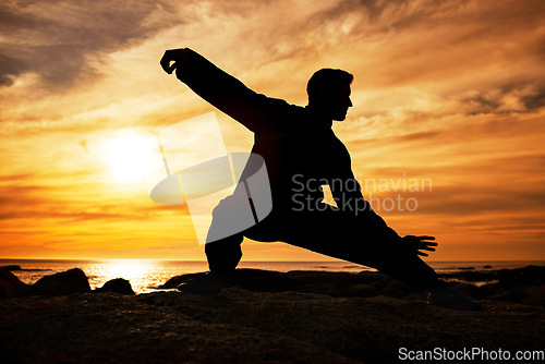 Image of Karate man, silhouette and tai chi with sunset sky on beach horizon for martial arts, taekwondo or fight exercise, training or practice. Art deco of athlete at sea for nature workout and fitness