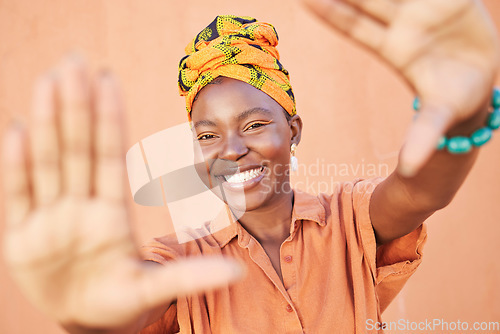 Image of Fashion black woman, face or framing hands on orange wall background in city for profile picture, Congo branding or clothing advertising. Portrait, smile or happy model in photography pov with turban