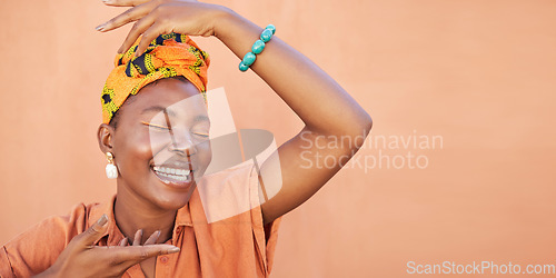Image of African, fashion and face of black woman on orange wall background with natural beauty, makeup and smile. Culture, hands and girl in Nigeria with designer jewelry, exotic cosmetics and head scarf
