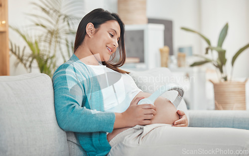 Image of Pregnant, woman and stomach with headphones for music for her unborn baby while relaxing at home. Belly, baby bump and pregnancy with a mother using a headset for audio or podcast streaming