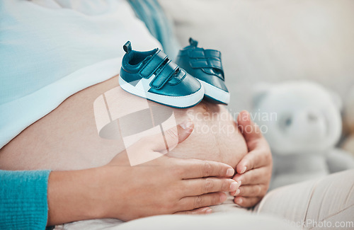 Image of Mother with pregnant stomach in hands, shoes for baby with pregnancy, relax and waiting for birth with love and hope for healthy child. Woman, prenatal care and mom at family home, ready for newborn.