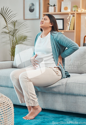 Image of Pregnant, back pain and woman with ache and body strain while sitting on her living room sofa. Belly, anatomy and pregnancy discomfort with a painful mother unhappy with physical condition at home
