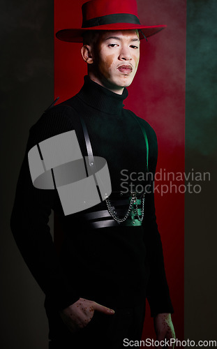 Image of Man, fashion and vitiligo skin on a studio background with smoke, beauty and aesthetic style with a red hat and black clothes. Portrait of male model with confidence, power and charm against backdrop