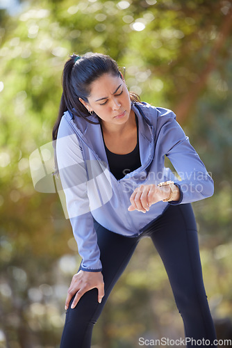 Image of Fitness, tired and woman with smart watch at park for running time, performance and cardio exercise outdoors. Female runner check stopwatch, clock and monitor heart rate, breathing and body wellness