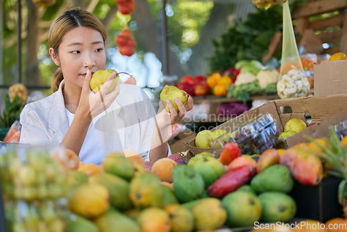 Image of Grocery shopping, Asian woman and fruit choice at outdoor market. Food, fruits and female smelling and choosing healthy, delicious and fresh pears for health, wellness and vitamin c at store or shop.