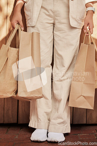 Image of Sustainability, fashion paper bag and woman legs for eco friendly, vegan and designer retail clothes in shopping, commerce and economy. Sustainable market, sale and discount of customer bag in hands