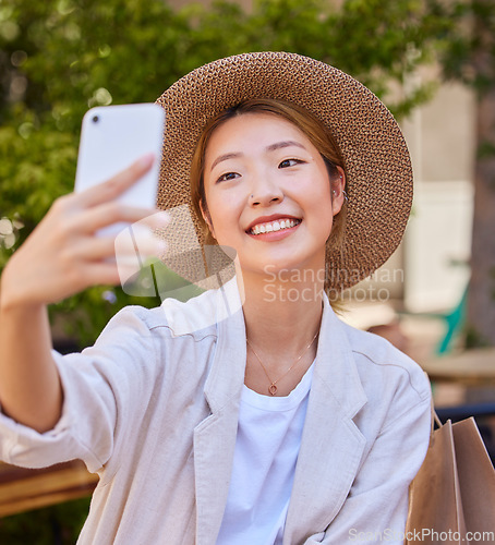 Image of Selfie, smartphone and shopping bag of woman in city or park for social media post, profile picture update and fashion blog in Japan. Cellphone photography, happy woman or influencer with retail tips