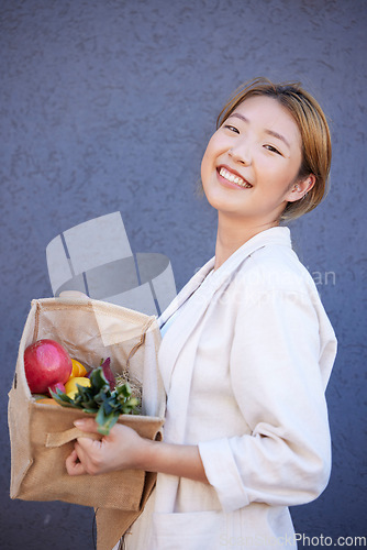 Image of Woman, face or grocery basket with organic fruit, healthy food or Japanese diet produce on blue background with mockup advertising space. Portrait, smile or happy customer with supermarket vegetables