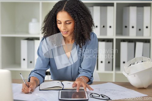 Image of Architecture, engineering and woman with blueprints writing notes on tablet and notebook in office. Strategy, planning and design, black woman architect working on building plans and online documents