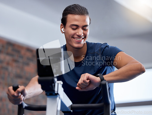 Image of Fitness, bike and man doing workout at the gym for cardio endurance, health and wellness. Sports, electric bicycle and healthy male athlete training or doing exercise with smart watch in sport center