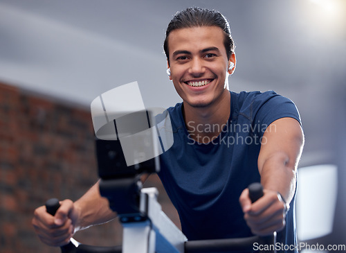 Image of Man, fitness and cycling at the gym for exercise, workout or healthy cardio training. Portrait, happy smile or exercising on stationary bicycle or bike machine for health, wellness or endurance sport