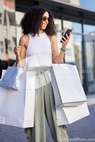 Image of Shopping, happy customer and woman with phone smile about shopping mall discount and sale. Black woman, shopping bag present and retail store fashion sales of a person on a mobile looking at text