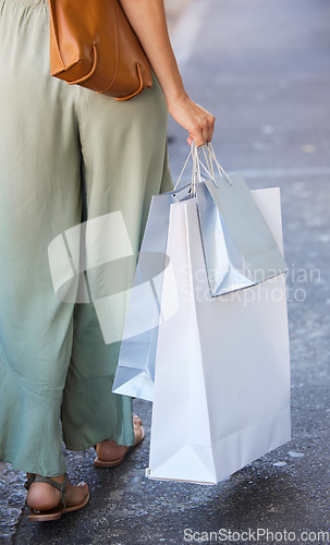 Image of Back of woman, fashion and shopping bag in city after buying clothing at luxury mall. Black Friday discount, sales deals and female with gifts in street after purchase at retail store or boutique.