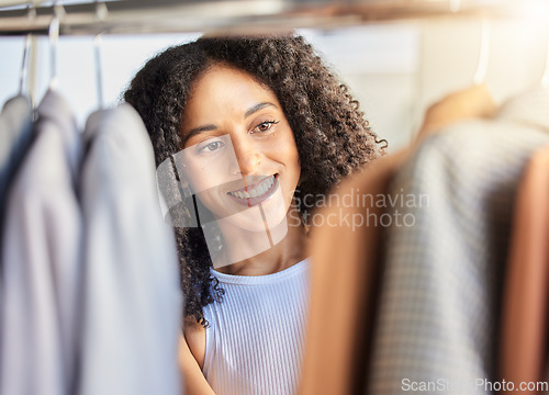 Image of Black woman, customer shopping and in store for clothes, sale items or smile. African American lady, young female or consumer purchase jackets, buying brand products or service in boutique or retail.