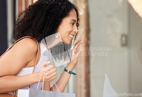 Image of Window shopping, black woman and shopping mall store with a customer looking at sale and discount. Retail shop, sales and luxury boutique windows with a person happy with shopping bag and smile