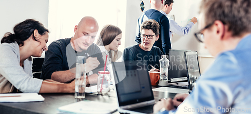 Image of Startup business and entrepreneurship problem solving. Young AI programmers and IT software developers team brainstorming and programming on desktop computer in startup company share office space.