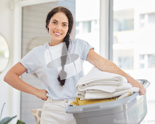 Image of Woman, laundry basket and home portrait in lounge, room and cleaning for service, chores and smile. Happy cleaner, clothes or clean fabric for hygiene, care or job in house, apartment or living room