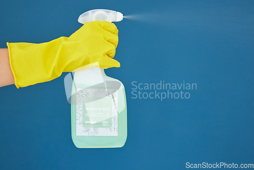 Image of Hand, spray and detergent for cleaning, hygiene or anti bacteria chemical against a blue studio background. Hands of glove spraying liquid bottle for washing, clean sanitary or disinfection on mockup