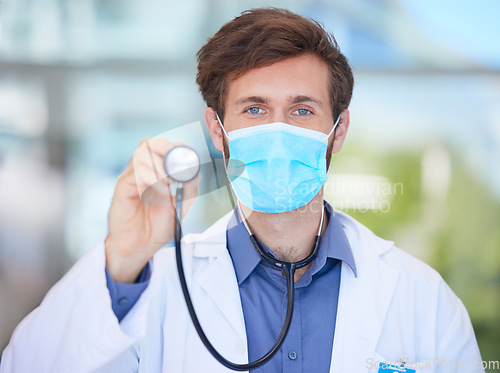 Image of Covid, cardiology and portrait of doctor with stethoscope to check, test and measure heart rate in clinic. Healthcare, face mask and male cardiologist for heart health, wellness and medical care