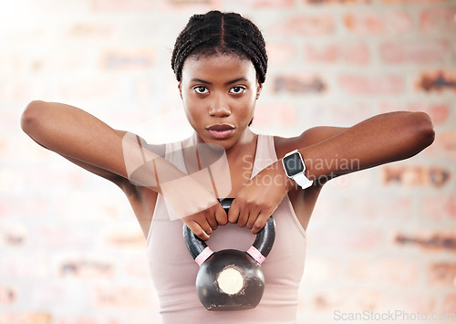 Image of Black woman, fitness and kettlebell with focus and exercise in gym, weights and muscle training with strong athlete and bodybuilding. Bodybuilder, workout and sport motivation with wellness portrait.