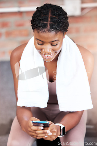 Image of Black woman, gym and smile with phone, social media or chatting on web, app or internet on break from workout. Woman, smartphone and fitness with comic meme, funny video or social network at training