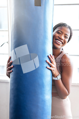 Image of Fitness, sport and boxing portrait with a woman holding a punching bag in a boxing gym for strength. Exercise, training and happy face of a martial arts fighter taking a break from kickboxing