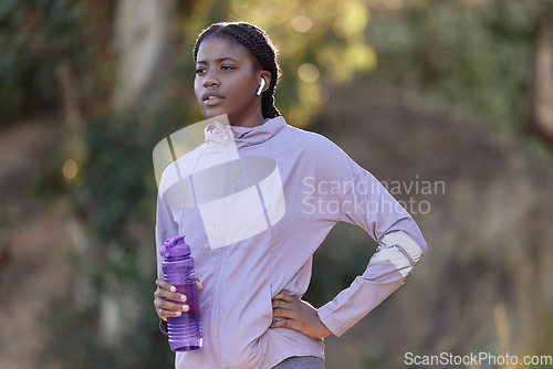 Image of Exercise, water bottle and black woman outdoor, fitness and workout for wellness, power or health. Nigerian girl, young female or athlete with liquid, hydration or training in nature, rest or earbuds