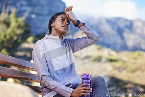 Image of Fitness, running and tired black woman on bench sweating from exercise, workout and marathon training. Sports, health and exhausted girl sitting to rest, break and relax with water bottle on mountain